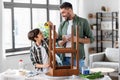 father and son with ruler measuring old table