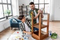 father and son with ruler measuring old table