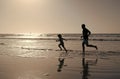 father and son running on beach. daddy with kid boy in sea or ocean. weekend family day. Royalty Free Stock Photo