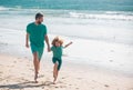 Father and son running on sea. Man famile relations concept.