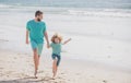 Father and son running on sea. Man famile relations concept.