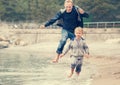 Father with son running on the sea surf line