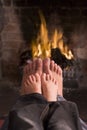 Father and son's feet warming at a fireplace
