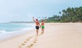 father and son in Santa hats walk on the sand tropical beach. Outgoing year concept