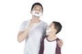 Father and son shaving beard on studio Royalty Free Stock Photo