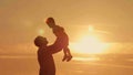 Father and son silhouettes play at sunset beach Royalty Free Stock Photo