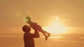 Father and son silhouettes play at sunset beach Royalty Free Stock Photo