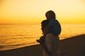 Father and son silhouettes at sunset on a sea beach. Royalty Free Stock Photo