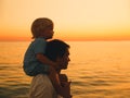 Father and son silhouettes at sunset on a sea beach. Royalty Free Stock Photo