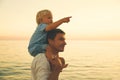 Father and son silhouettes at sunset on a sea beach. Royalty Free Stock Photo