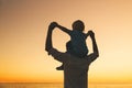 Father and son silhouettes at sunset on a sea beach. Royalty Free Stock Photo