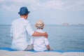 Father and son sit on the sea pier and look on the ship on horizont line Royalty Free Stock Photo