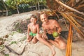 Father and son sit in selfmade hut of branches and play in Robin