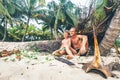 Father and son sit together on selfmade hut and play as Robinzones