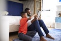 Father With Son Sitting In Bedroom Playing Game On Digital Tablet Together Royalty Free Stock Photo