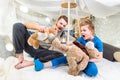 Father and son sitting in blanket fort and playing with teddy bears Royalty Free Stock Photo