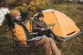 Father and son sitting on folding chairs son looking