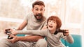 Father and Son Sitting and Playing on Console.