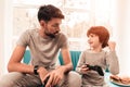 Father and Son Sitting and Playing on Console.