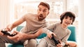 Father and Son Sitting and Playing on Console.