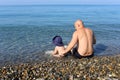 Father and son sitting on the seaside