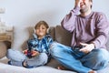 Father And Son Sitting On Sofa In Lounge Playing Video Game Royalty Free Stock Photo
