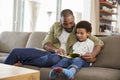 Father And Son Sitting On Sofa In Lounge Reading Book Together Royalty Free Stock Photo