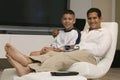 Father and Son sitting Together on chair in Living Room portrait Royalty Free Stock Photo