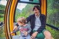 Father and son in ski lift cabin in summer. Passengers on a cable car