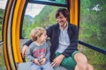 Father and son in ski lift cabin in summer. Passengers on a cable car