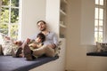 Father And Son Sleeping On Window Seat At Home Together