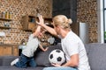 father and son with soccer ball giving high five while sitting together Royalty Free Stock Photo