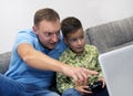 Father and son spending time together and playing computer game. Royalty Free Stock Photo