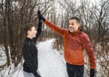 father with son sport running together outside in winter season doing high five Royalty Free Stock Photo