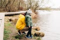 Father and son stand on the shore of the lake and playing with water. Happy family with child kid boy playing and having Royalty Free Stock Photo