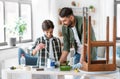 father and son stirring grey color paint at home Royalty Free Stock Photo