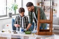 father and son stirring grey color paint at home Royalty Free Stock Photo