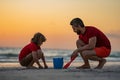 A Father with a son at the sunset. Kid and father building sandcastle. The Father and the son playing on the beach Royalty Free Stock Photo