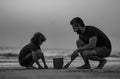 A Father with a son at the sunset. Kid and father building sandcastle. The Father and the son playing on the beach Royalty Free Stock Photo