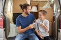 Father And Son Take A Break In Back Of Removal Van On Moving Day Royalty Free Stock Photo