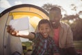 Father and son taking selfie with mobile phone in park Royalty Free Stock Photo