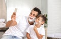 Father and son taking selfie while shaving Royalty Free Stock Photo