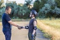 Father and son teenager in helmet and black T-shirt spend time together on the playground shake hands. Strong male handshake.
