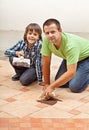 Father and son testing the joint material color on ceramic tiles