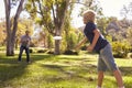 Father And Son Throwing Frisbee In Park Together