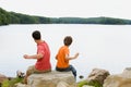 Father and son throwing rocks into lake Royalty Free Stock Photo