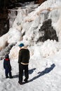 A father and son to a hike to a frozen water fall