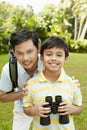 Father and son together, boy holding binoculars. Conceptual image