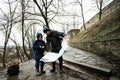 Father and son tourist look at map, stand on wet path to an ancient medieval castle fortress in rain