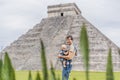 Father and son tourists observing the old pyramid and temple of the castle of the Mayan architecture known as Chichen